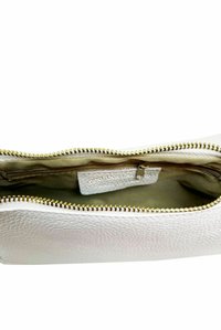 Valkoinen nahkapussukka, jossa on teksturoitu pinta, kultaiset vetoketjuvarusteet ja beigekerroksellinen vuori, jossa on pieni vetoketjullinen tasku.