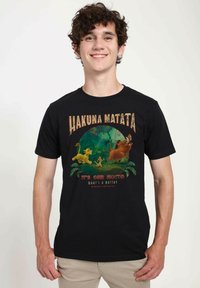 Černé bavlněné tri�čko s barevným grafikou postav a textem "Hakuna Matata" na zeleném pozadí džungle.