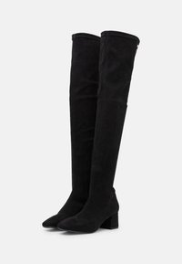 Stivali neri sopra il ginocchio in suede, con punta affusolata, tacco a blocco e texture liscia. Accentuati da dettagli di cucitura.