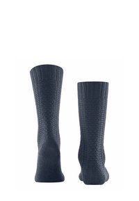 Calze lavorate a maglia di un blu scuro con un motivo testurizzato e polsini a coste, caratterizzate da un colore uniforme e progettate per comfort e calore.