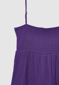 Lila smockad klänning med tunna justerbara axelband, texturerad tyg, samlad midja och svävande kjol.