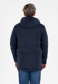 Dunkelblaues isoliertes Jacket mit Kapuze, das eine glatte Textur aufweist und einen längeren Schnitt hat, der über die Taille hinausgeht. Keine sichtbaren Beschläge.