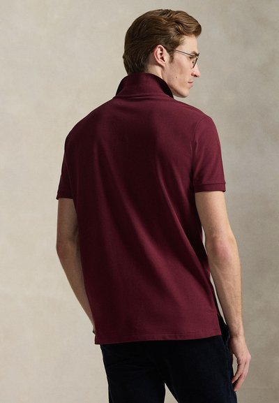 Burgunderfarget polo-skjorte med brettet krage og korte ermer, laget av glatt bomullsstoff. Har et rent design uten synlige mønstre.