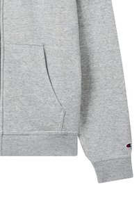 Grau zip-up Kapuzenpullover aus weichem Baumwoll-Mischgewebe. Mit Fronttaschen, gerippten Bündchen und einem Logoakzent am Ärmel.