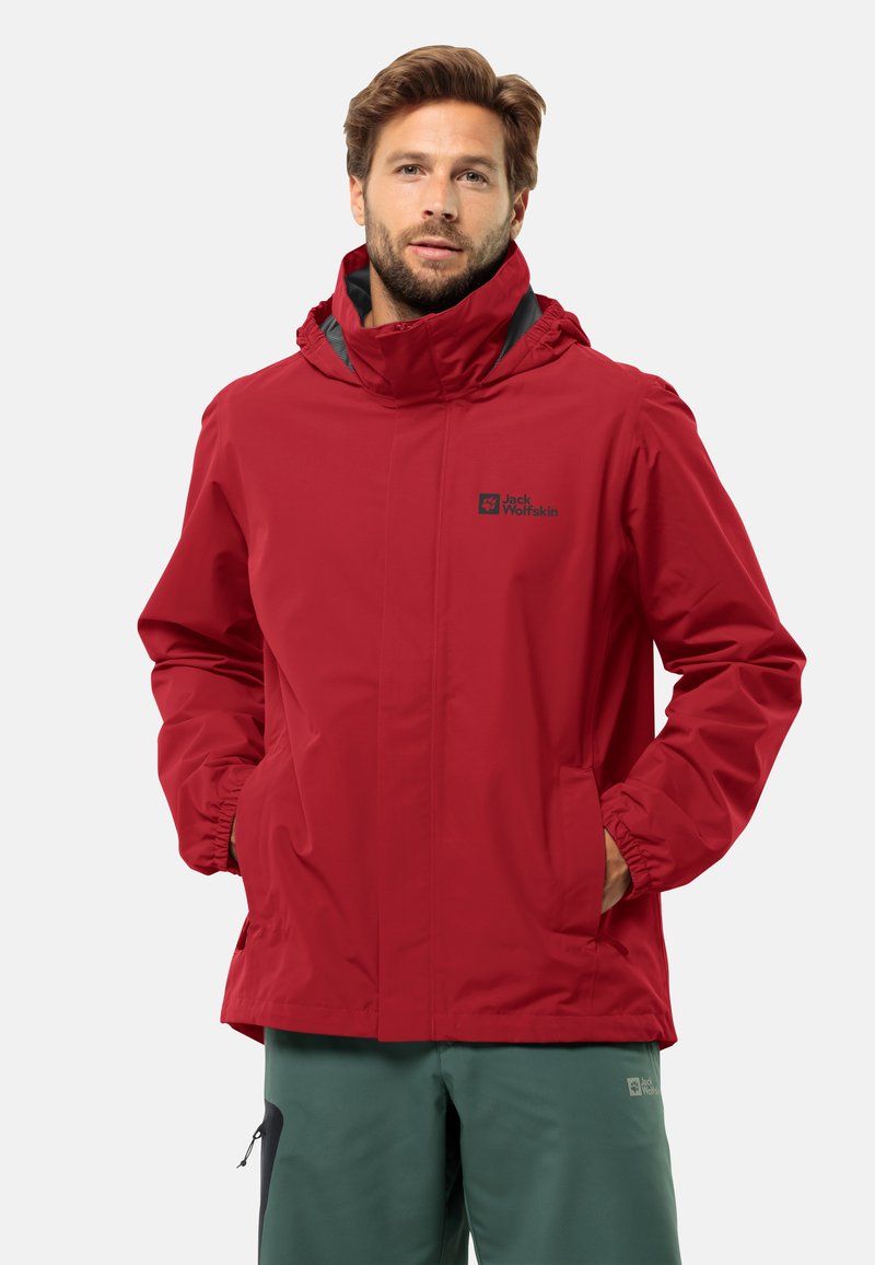 Giacca impermeabile rossa con colletto alto, cappuccio regolabile, polsini elasticizzati e tasche laterali. Presenta un logo sul petto e una texture liscia.