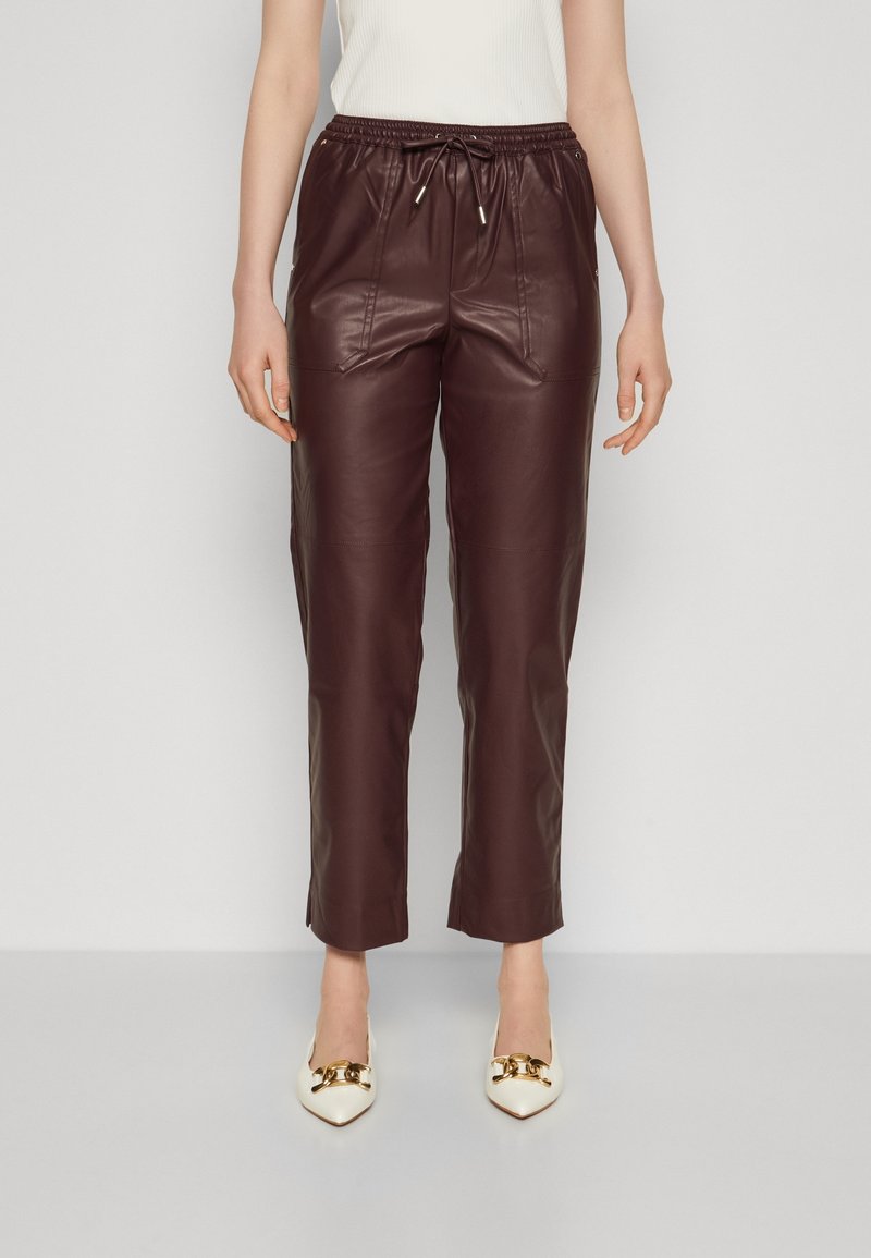 Bordowe joggery ze skóry z elastycznym paskiem w talii, sznurkiem i przednimi kieszeniami, o gładkiej fakturze i skróconym kroju.