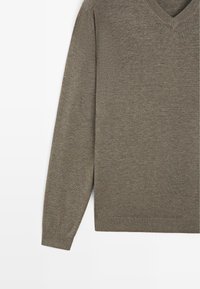 Sweter z długim rękawem i dekoltem w serek w kolorze oliwkowej zieleni, z prążkowanymi mankietami i dołem, wykonany z cienkiej dzianiny.