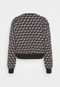 Bluza w czarno-biały wzór z powtarzającym się motywem, ściągaczami na rękawach i u dołu. Miękka tkanina o krótkim fasonie.