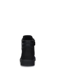 Stivaletto nero alla caviglia con una superficie in pelle liscia, punta rotonda e collare imbottito. Presenta una zip laterale per una facile vestibilità e una suola in gomma texture.