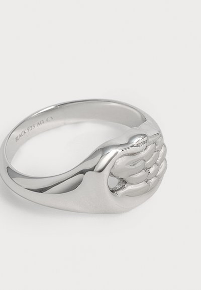 Bague en argent avec un design détaillé d'une main sculptée entrelacée sur le dessus, anneau lisse et texte gravé à l'intérieur.