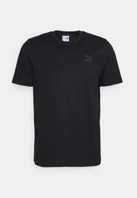 T-shirt en coton noir avec un col rond. Présente un petit logo noir sur la poitrine gauche. Manches courtes et coupe régulière.