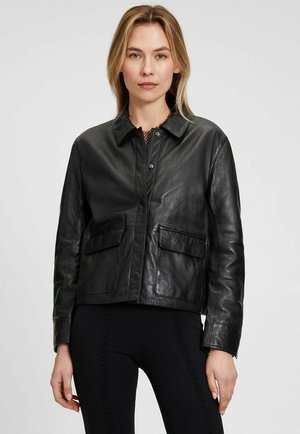 Giacca nera in pelle con colletto, due tasche frontali e design aderente. Texture morbida e dettagli hardware minimali.
