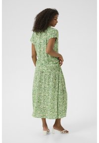 Grön blommig midi-klänning med korta puffärmar, mjukt tyg och en flödande kjol. Har ett litet blommönster och en avslappnad passform.