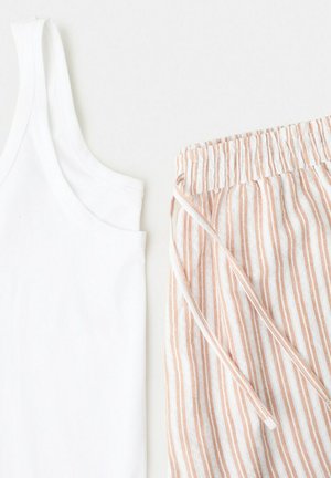 Hvid ærmeløs tanktop kombineret med beige og hvide lodrette, stribede elastik-bukser med snøre i taljen på en lys baggrund.
