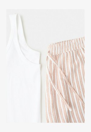 Hvid ærmeløs tanktop kombineret med beige og hvide lodrette, stribede elastik-bukser med snøre i taljen på en lys baggrund.