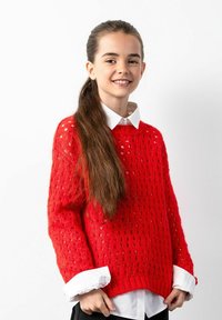 Czerwony sweter z wełny, charakteryzujący się otwartym splotem, długimi rękawami i luźnym krojem, noszony na białej koszuli z kołnierzykiem.