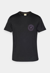 Svart T-skjorte med korte ermer laget av mykt stoff, har et sirkulært lilla logo med et tre-design på venstre brystområde.