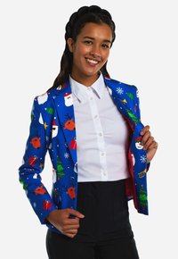 Blue blazer with festive patterns including Santa, reindeer, Christmas trees, and snowflakes. Lining is red; worn over a white shirt.