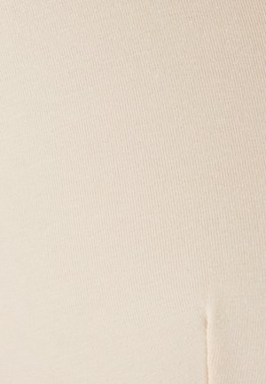 Tessuto beige a coste con una consistenza morbida, che mostra sottili linee orizzontali e una leggera elasticità, con una cucitura di dettaglio lungo il bordo.