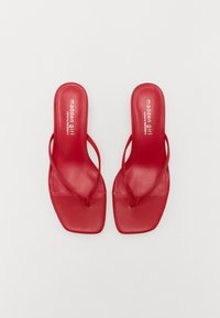 Røde syntetiske hæle sandal med et strap-design og firkantede tæer. Glat overflade, minimal branding og flad sål for nem brug.