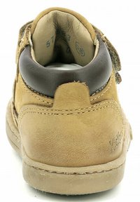 Scarpa scamosciata color tan con colletto in pelle marrone, tacco arrotondato, suola in gomma beige e dettaglio di cucitura visibile. La vista posteriore mostra l'imbottitura interna morbida.