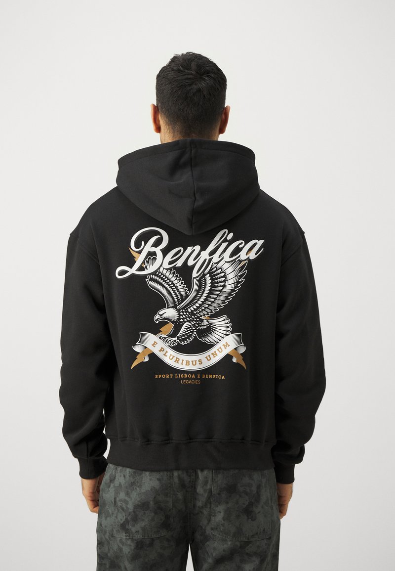 Crna dukserica s velikom grafikom orla i natpisom "Benfica" u bijeloj i zlatnoj boji. Mehak materijal, prednji džep i kapuljača s podesivim vezicama.