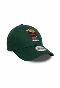Dunkelgrüne Baseballmütze mit einem gestickten Bären, der einen rot-schwarzen Pullover, blaue Jeans und weiße Schuhe trägt und winkt.