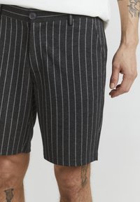 Bermuda grigie a righe realizzate in morbido tessuto, con righe bianche verticali, chiusura con bottone e tasche laterali.