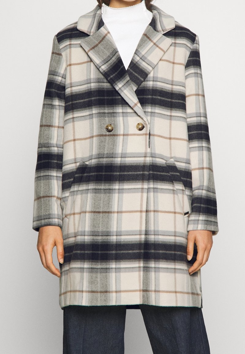 Dubbelknäppt rutigt kappa i grädde, marinblå och bruna nyanser. Tillverkad av ett mjukt, strukturerat tyg med sidofickor och spetsad krage.