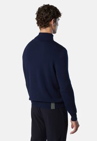 Maglione lavorato a maglia blu navy con colletto alto. Presenta polsini e orlo a coste con un accento verde a contrasto nella parte inferiore. Design semplice.