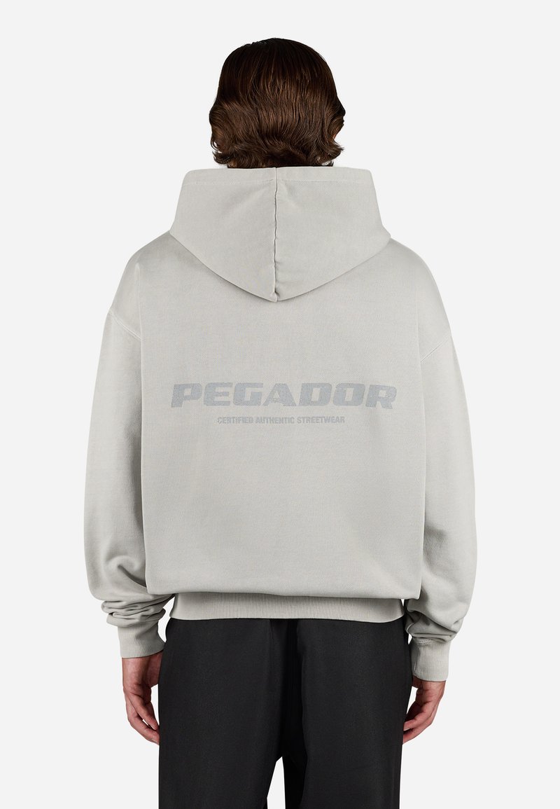Sweatshirt cinza claro com uma grande estampa nas costas que diz "PEGADOR" e "CERTIFICADO AUTÊNTICO STREETWEAR." Corte largo com punhos canelados.