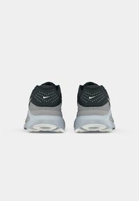 Nike Laufschuhe in Schwarz und Grau, mit einem Mesh-Obermaterial, gepolstertem Kragen und Flexrillen in der weißen Gummisohle.