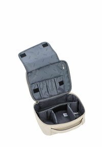 Trousse de maquillage beige avec un extérieur texturé, un intérieur en nylon gris, plusieurs compartiments et une poche zippée. Fermeture avec du Velcro.