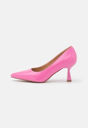 Escarpin à talon haut brillant rose à bout pointu avec un talon fin et incurvé et une doublure intérieure beige sur un fond blanc uni.