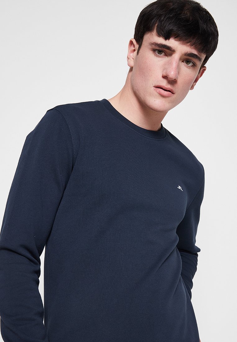 Navy Langarm-T-Shirt aus glattem, geripptem Stoff, mit Rundhalsausschnitt und kleinem Logo auf der Brust.