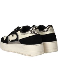 Zwarte en crèmekleurige sneakers met accenten van suede en slangenprint, met een dikke witte zool en ronde veters. Opvallende textuurdetails op de hiel.