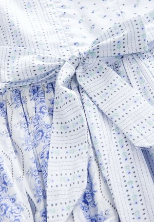 Blå og hvid mønstret kjole med blomstermotiver og striber. Materialet er let bomuld med et bindebælte som detalje.