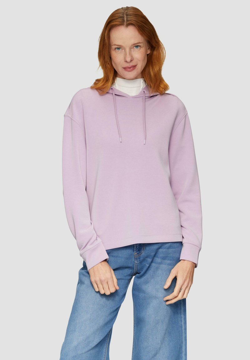 Felpa con cappuccio di colore lilla chiaro, con coulisse, maniche ampia e un fit rilassato, abbinata a jeans blu. Texture liscia, design casual.