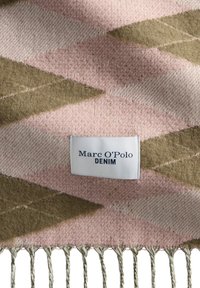 Tkany koc z różowymi i oliwkowozielonymi wzorami w zygzak, z frędzlami na brzegach oraz białą metką z napisem "Marc O'Polo DENIM".