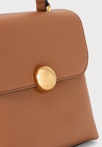 Brown leather handbag with a textured finish, featuring a rounded gold-tone clasp with embossed lettering and a sleek, structured shape.