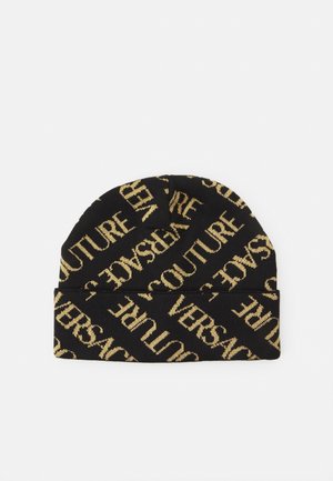 Bonnet en tricot noir avec un revers plié présentant un motif de texte doré en diagonale répétant "VERSACE COUTURE".