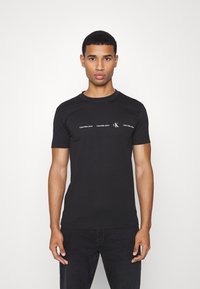 Calvin Klein Jeans REPEAT LOGO TEE UNISEX - T-shirt estampada - black