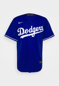 Jersey de béisbol azul con texto blanco "Dodgers", con cierre de botones en la parte delantera y mangas cortas con acentos blancos. Fabricado con material ligero.