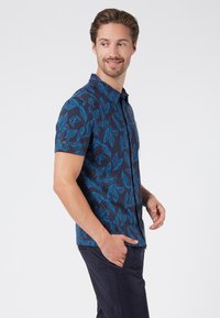 Kortärmad skjorta med knappar, marinblå bas med blå bladmönster, i bomull, smal passform, spetsig krage, ficka på vänster bröst, lätt textur.