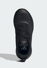 Chaussure de sport noire en mesh et en matériaux synthétiques. Présente une tige texturée, un bout arrondi, des lacets et des accents de logo sur la languette.