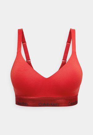 Červená braletka s hlubokým výstřihem do V, nastavitelnými ramínky a elastickým páskem s logem "Calvin Klein" v černé barvě. Měkká textilie.