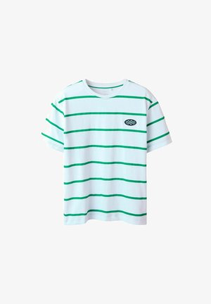 T-shirt blanc à manches courtes avec des rayures horizontales vertes et un patch ovale noir sur la poitrine affichant "1986" en texte blanc.