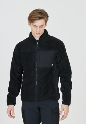 Black fleece jacket with a zip front, high collar, and a patch pocket. Features soft, textured fabric and contrasting black panels.