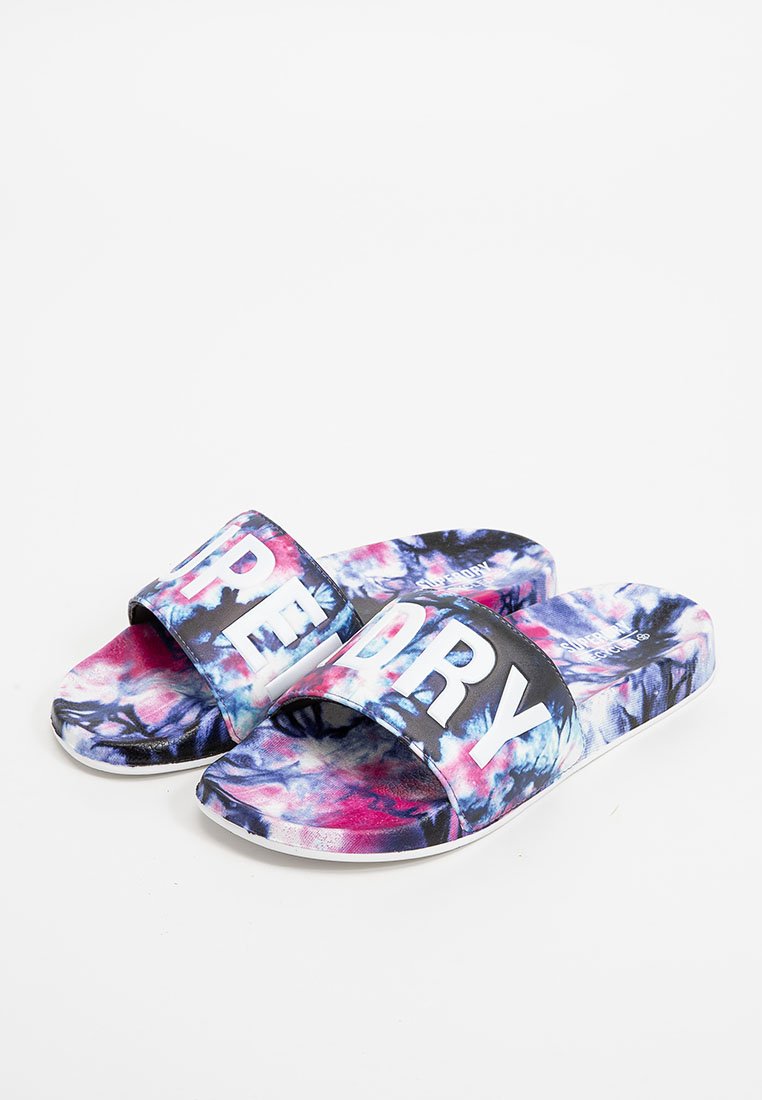 Bunte Rutschsandalen mit einem Batikmuster in Pink, Blau und Lila. Sie haben einen breiten schwarzen Riemen mit auffälliger weißer Schrift "DRY."