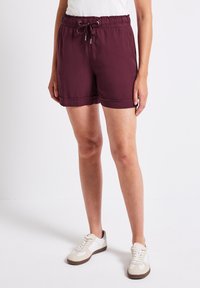 Bordeaux pull-on shorts met een elastische tailleband en trekkoorddetail, met een gladde textuur en een binnenbeenlengte tot halverwege de dijen.